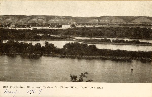 View looking toward old Diamond Jo Warehouse, before the bridge was built. Caption reads: "Mississippi River and Prairie du Chien, Wis., from Iowa Side".