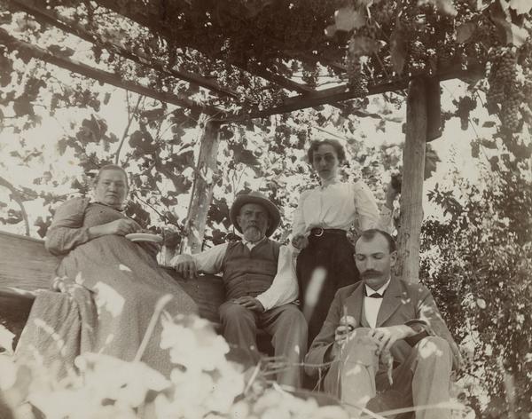 Mr. Henry and Mrs. Ella Hoffman with unidentified couple under a grape arbor.