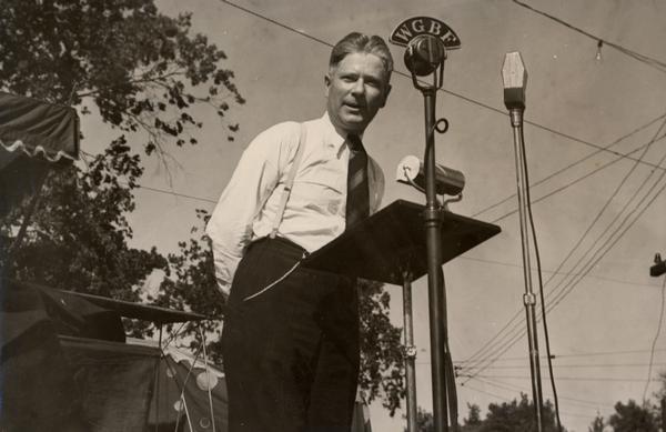 Philip F. La Follette speaking to a radio audience during his unsuccessful gubernatorial reelection bid during the summer of 1938.  La Follette, the son of Robert M. La Follette, Sr., served three two-year terms as governor. Like his father Phil La Follette was well-known for his public speaking.  The microphone suggests he was speaking somewhere near Evansville, Indiana, not in Wisconsin.