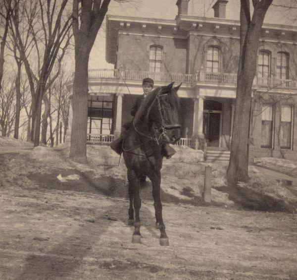 Philip F. La Follette on horseback in front of the old Governor's Mansion on Gilman Street, sometime during the years that his father, Robert M. La Follette, Sr., was governor of Wisconsin, probably about 1904.