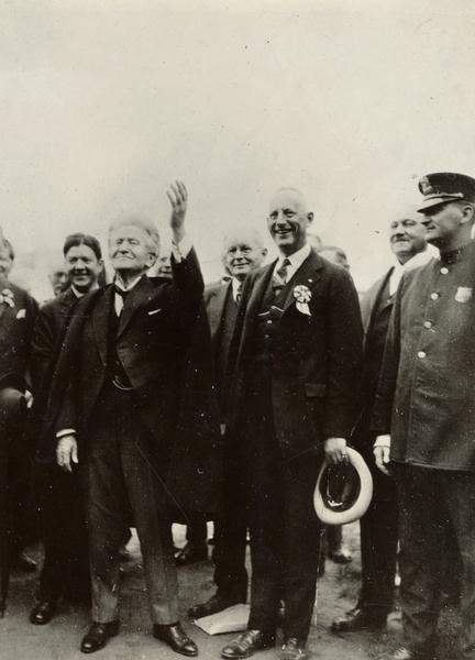 Senator Robert M. La Follette, Sr., waves to the crowd at the close of a presidential campaign speech at Yankee Stadium.  Robert M. La Follette, Jr., is behind the senator and to his right.