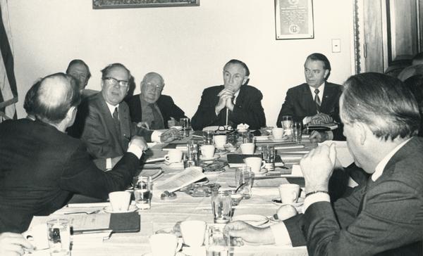 Senator William Proxmire (bald head toward the camera) makes a point with Majority Leader Mike Mansfield (center) at a meeting of the Senate committee chairmen.