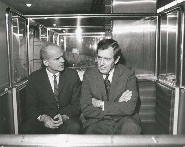 Senator William Proxmire chatting with Senator Edwin Muskie of Maine while riding on the U.S. Capitol subway.