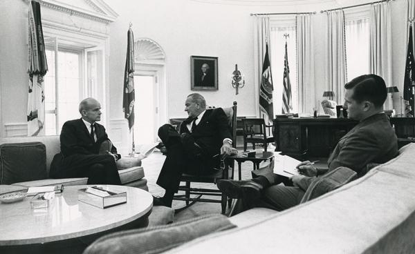 Senator William Proxmire meeting with President Lyndon Baines Johnson (LBJ), in the Oval Office at the White House.  The third person in the photograph, who is taking notes on their conversation, is unidentified.
