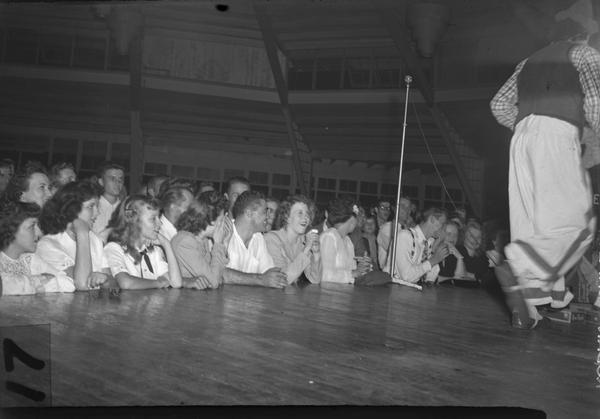 Young people at a union-sponsored dance in Milwaukee crowd around the stage, perhaps while the band is taking a break.