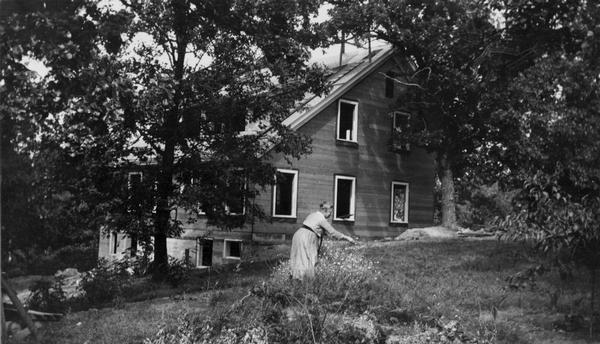 The residence of Professor A.S. Flint at 122 Bascom Place, under construction. A woman (Mrs. Flint?) is in the front yard.