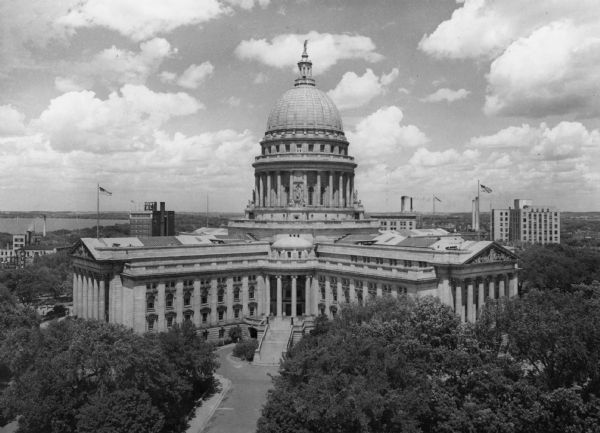 Elevated view of the Wisconsin State Capitol. The Belmont Hotel is behind the capitol on the left, and beyond is Lake Mendota.