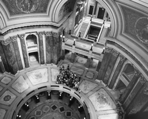Partial view from above of the Wisconsin State Capitol rotunda, with a group of people on the balcony looking toward the North Gallery.
