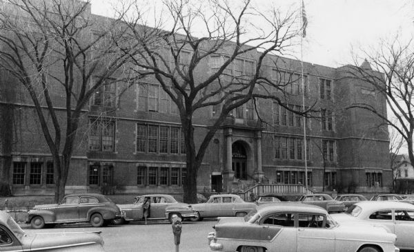 Exterior view of Central High School with cars parked in front.