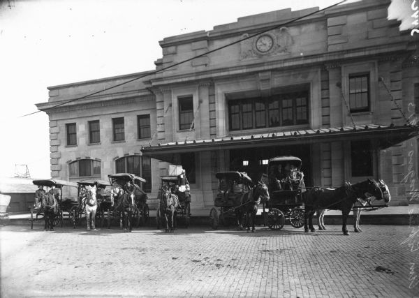 Horse-drawn American Express wagons in front of the Chicago & Northwestern Railroad Depot.