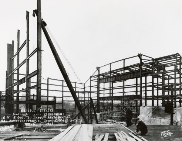 Early view of the construction of the Capitol Theatre revealing the steel frame of the building. Two men are working on the right.