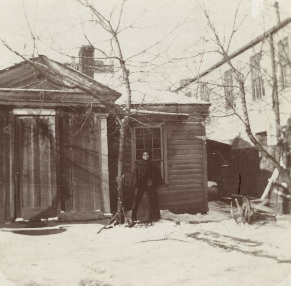 The James Duane Doty residence on Doty Street (formerly Clymer Street), the first "Executive Mansion" in Madison, occupied in 1841-1844 by the Territorial Governor. Jane Williams is standing by the door; she was a sister of "Prof." Williams, an African American barber, who had at one time been valet to Edwin Forrest, the actor.