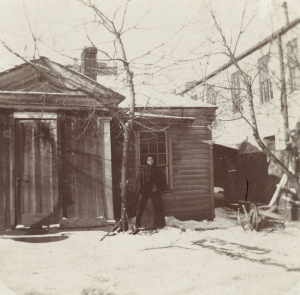 The James Duane Doty residence on Doty Street (formerly Clymer Street), the first "Executive Mansion" in Madison, occupied in 1841-1844 by the Territorial Governor.  Jane Williams is standing by the door; she was a sister of "Prof." Williams, an African American barber, who had at one time been valet to Edwin Forrest, the actor.