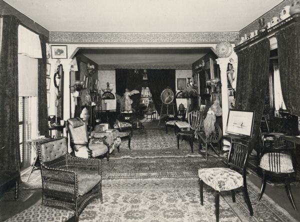 The parlor of the Lucius Fairchild residence at 302 Monona Avenue in Madison, filled with artwork and furniture collected by the Fairchilds during their residence abroad during the 1870s.  Among the artworks that can be seen is a portrait of Sarah Fairchild Dean Conover, sister of Lucius Fairchild, painted by Eastman Johnson.  This painting is now part of the collection of the Historical Society Museum, see Image #2590 or Museum #1942.2