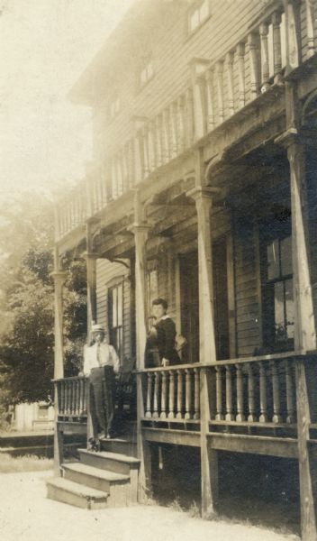 People standing on the front porch of the Flom Hotel on East Main Street.