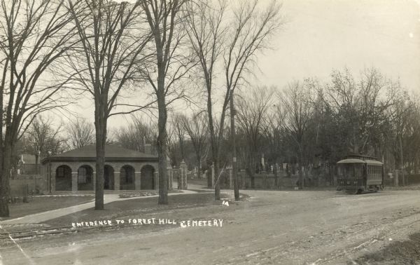 Entrance to the Forest Hill Cemetery, with a streetcar on the right.