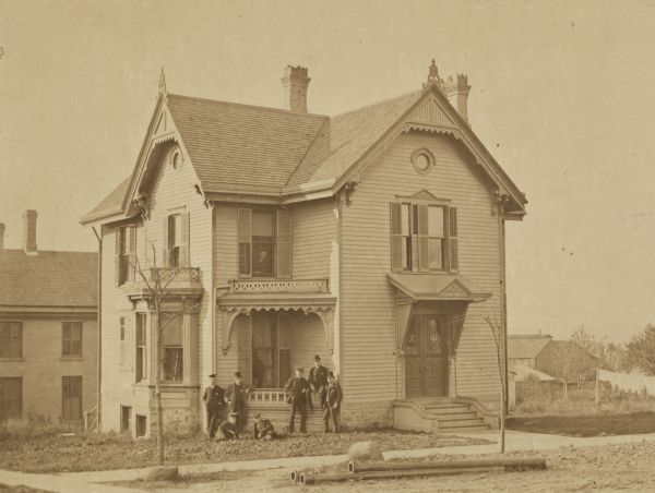 A view of the Chi Psi chapter house at 602 North Frances Street, looking northwest at the intersection of Frances and Langdon Streets. A group of people are posing in front. In 1892, a lodge was erected at 627 North Lake Street.