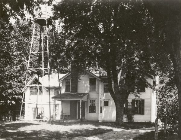 The J.C. Hawley house, also known as the Evergreens, which stood on a site at Badger Road that later became a highway interchange. A water tower is on the left in front of the house.