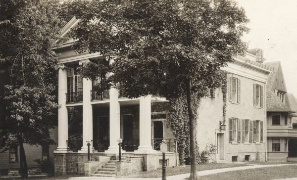 View from street towards the front and right side of the house at 524 North Henry Street, looking south at the intersection of Henry and Langdon Streets. This Greek revival residence was erected in 1851 for J.T. Marston. The location he chose for his house was then considered to be quite remote from the rest of the town, which was clustered around the Capitol. From 1909 to 1923, the house was used by the Delta Kappa Epsilon fraternity. From 1925 to around 1942 and again from 1946 until its demolition in 1962, it was used by the Alpha Chi Rho fraternity.
