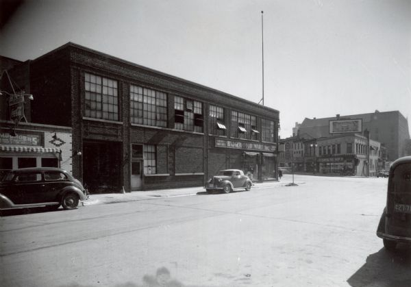 A view down North Henry Street, looking toward State Street, showing the Badger Food Mart and the Capitol Tog Shop.