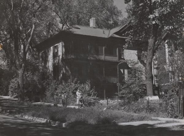 The Herfurth house, 703 East Gorham Street, built by Theodore Herfurth around 1870 and owned in 1952 by Mrs. Ralph Dennis. People are standing on the sidewalk in front.