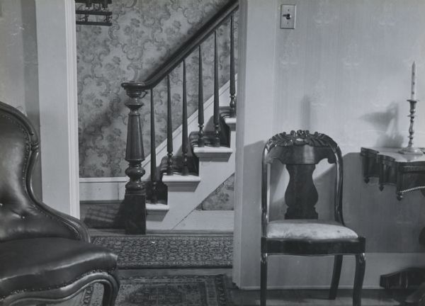 The newel post and front stairs of the Herfurth house, 703 East Gorham Street, as seen from the living room or parlor.