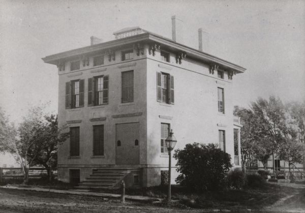 A view looking southeast of the Newell H. and Helen Dodge residence at 1121 West Johnson Street, on the corner of North Charter Street. The house may have been built around 1850. It was demolished between 1962 and 1963 to enable construction of the University of Wisconsin Zoology Research building. Dodge came to Madison with his parents in 1850. He is first listed as residing here in 1875. He was then shown to be a clerk, later a merchant in the fuel business(1890), an insurance agent (1900), and finally an attorney (1902). He died in January 1934 at the age of 88.  His obituary says he was a Madison councilman (5th Ward) and member of the Dane County Bar. His wife died in 1915.