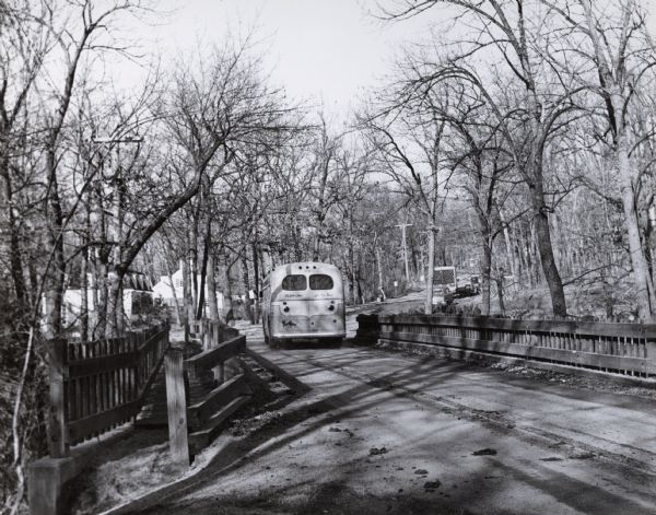 A public bus crosses the bridge over a ravine on Lake Mendota Drive in Shorewood, looking east.