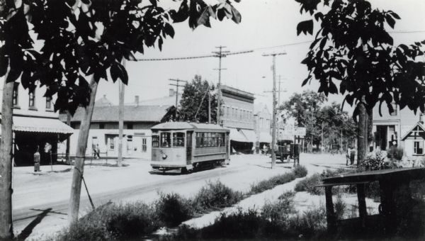 View over sidewalk of a street railroad car passing the old Northwestern Railroad Station on the 400 block of West Lakeside Street.