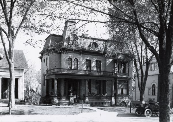 John J. Suhr residence at 121 Langdon Street, designed by City Engineer and architect Captain John Nadar. Built in 1886 for immigrant John J. Suhr, Sr. (1836-1901), founder of the German-American Bank, later renamed the American Exchange Bank. A group of women are sitting on the front porch. This is reportedly the first private dwelling in the city to feature steam-heating. At right, the Alexander H. Main residence, built 1892.