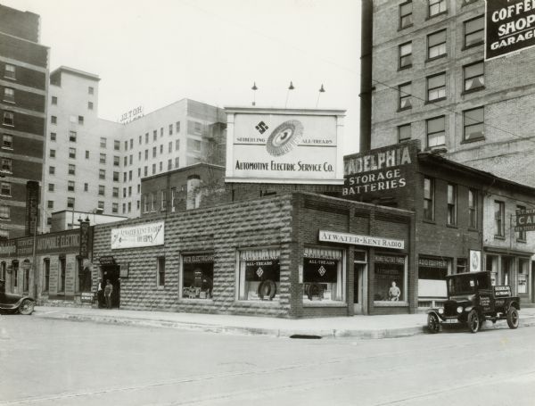 Madison's Automotive Electric Service Company at 122-124 West Main Street. The Loraine Hotel can be seen in the left background.