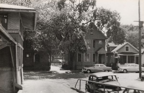 View of two houses (108 N. Blount and 102 N. Blount) on North Blount Street taken from Market Place showing a corner of the City Market on the left.