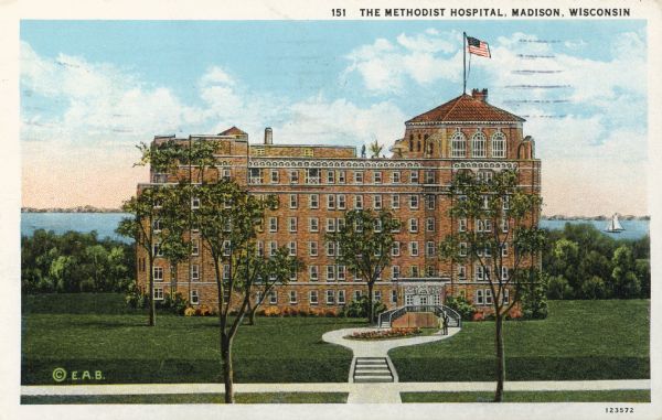 Slightly elevated view of the Methodist Hospital. A lake is in the background. Caption reads: "The Methodist Hospital, Madison, Wisconsin".