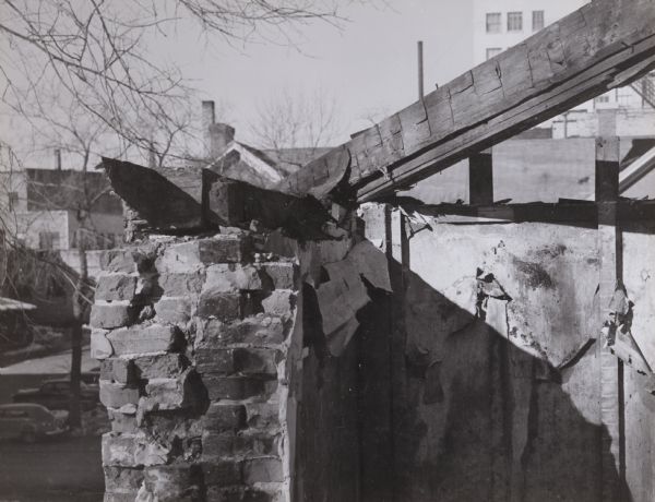 Atwood / Buck-Neckerman House, at 210-214 Monona Avenue (now Martin Luther King, Jr. Boulevard), built by General David Atwood and his partner Royal Buck as a double house in the late 1840s and later lived in by George and Elizabeth Neckerman. Detail of the attic wall and roof beams. The beams are hand-hewn and laid up with handwrought square nails. The very thick walls were plastered on the inside and then wallpapered. For some reason this was unsatisfactory and furring strips were nailed over the papered wall. Wooden lathe and plaster followed with a final covering of wallpaper.