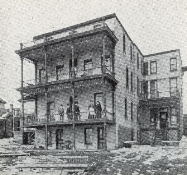 Hotel Ogden on East Wilson Street. This may be a view of the back. People are standing on the second story porch.