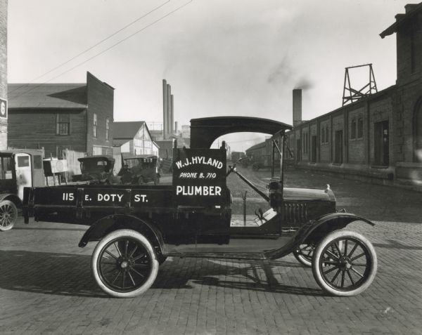 Ford truck of Madison plumber W.J. Hyland parked outdoors.