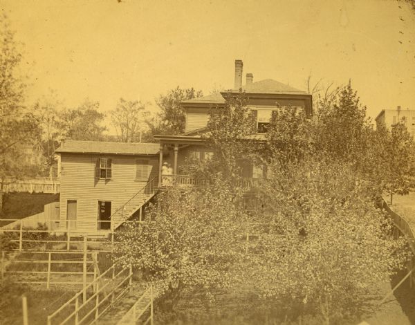 Elevated view of the Spooner residence on the south corner of Wilson and Carroll Streets. This residence was home to John C., Phil H. and Roger Spooner. On the porch of the house are two women.