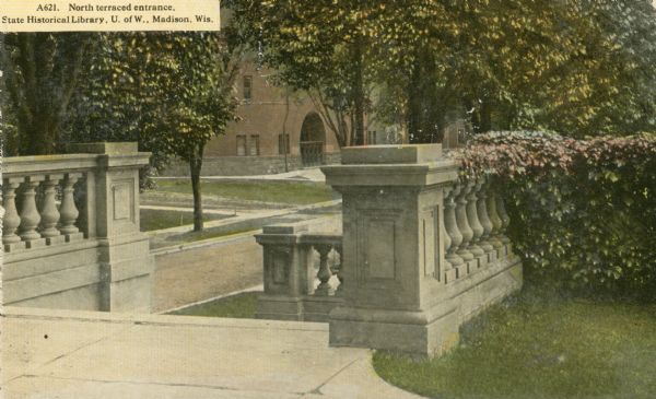 View towards the terraced steps and balustrades leading down to the sidewalk, at the North, Langdon Street, entrance of the State Historical Society. The Armory (Red Gym or Old Red) is visible across Langdon Street. Caption reads: "North terraced entrance, State Historical Library, U. of W., Madison, Wis."