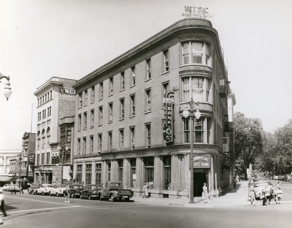 View from intersection towards the Wisconsin Building, which was built in 1901. Located at the intersection of State and Carroll Streets, at 102 State Street. When this photograph was taken, the building was home to the Commercial State Bank.