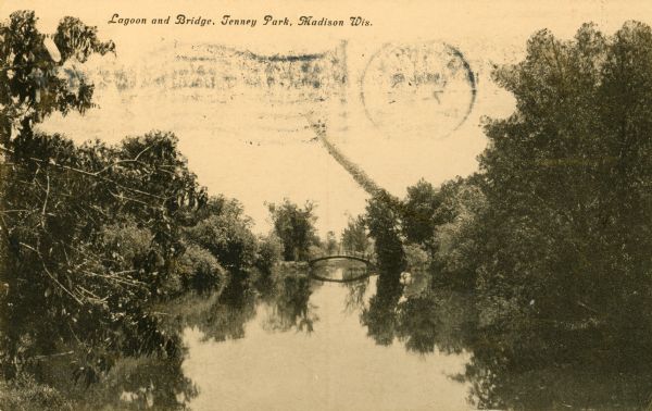 View of the lagoon at Tenney Park, surrounded by trees, with a bridge in the distance. Caption reads: "Lagoon and Bridge, Tenney Park, Madison, Wis."