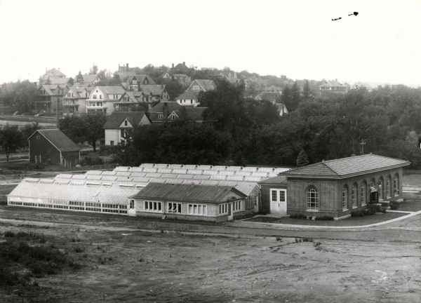 View looking southwest at the University Heights neighborhood from near the corner of University Avenue and Breese Terrace. In the foreground is the University of Wisconsin horticulture potting shed and greenhouses.