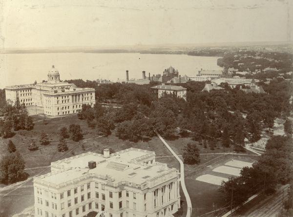 Elevated view looking northeast from the chimney of the Power Plant on University Avenue. The Chemistry Building is in the foreground, and Bascom Hall and Lake Mendota are in the background. Numerous other University of Wisconsin buildings including South Hall. Visible at right center may be the construction site of Lathrop Hall, completed in 1910.