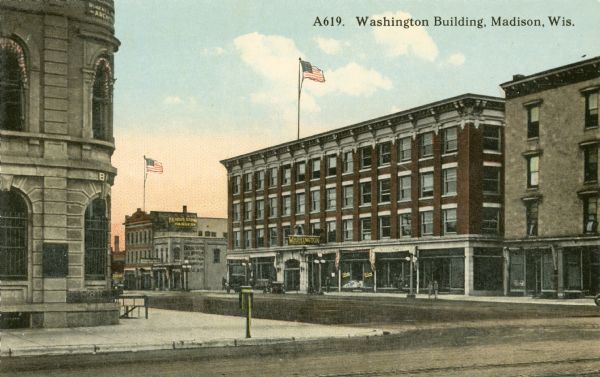 View across intersection towards the Washington Building, located on East Washington Avenue between Webster and Pinckney Streets. Caption reads: "Washington Building, Madison, Wis."