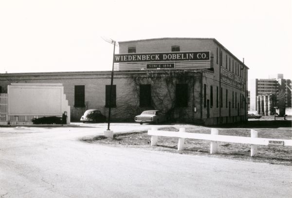 Wiedenbeck Dobelin Company, located at 619-23 West Mifflin St. View taken from West Washington Avenue. Founded by Theodore E. Wiedenbeck, Charles W. Dobelin, and Milton Brinkhoff in 1894, the company became a successful hardware distributor.