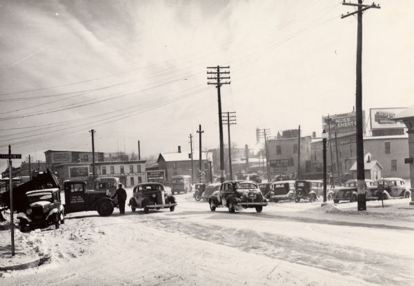 Automobiles travel  snow-covered East Wilson and Williamson Streets.