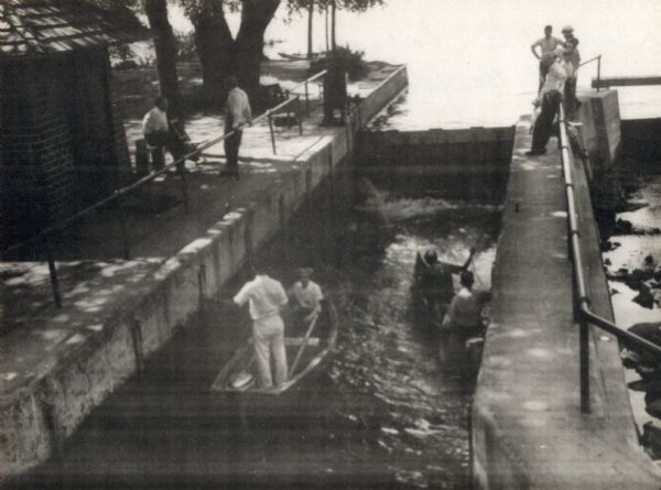 Several men pass through the locks at the Lake Mendota entrance to the Yahara River.