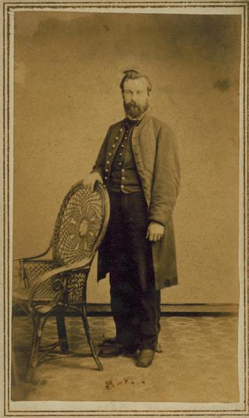 Full-length carte-de-visite portrait of Joseph L. Smith of Evansville, Wisconsin, a member of the 1st Brigade, 3rd Division, 15th Army Corps Band. Discharged April 5th, 1865 due to disability.
