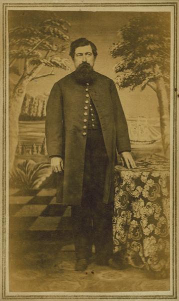 Full-length carte-de-visite portrait in front of a painted backdrop of Charles C. Stone of Decatur, Wisconsin, a member of the 1st Brigade, 3rd Division, 15th Army Corps Band. Discharged April 1st, 1865 for a disability.