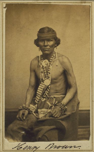 Three-quarter length portrait of Henry Brown, sitting, of the Ho-Chunk (Winnebago) tribe.  Brown died in Nebraska prior to 1926.