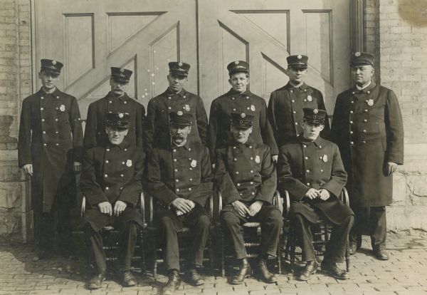 A formal portrait of police officers in front of a building.